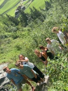 Jugendliche beim Wandern im Grünen, mit Berglandschaft im Hintergrund, Österreich